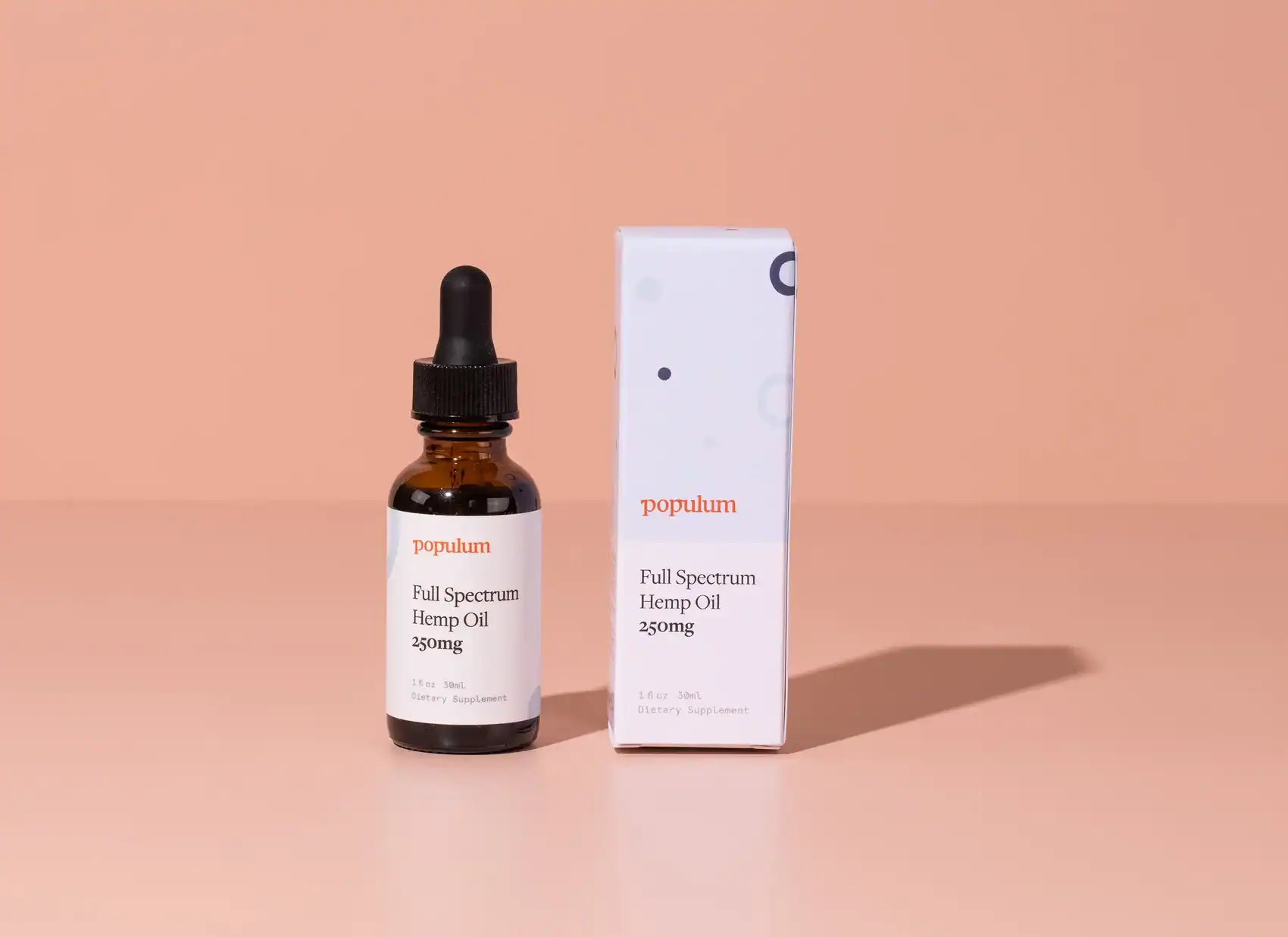 CBD oil bottle and box displayed on a soft peach background.