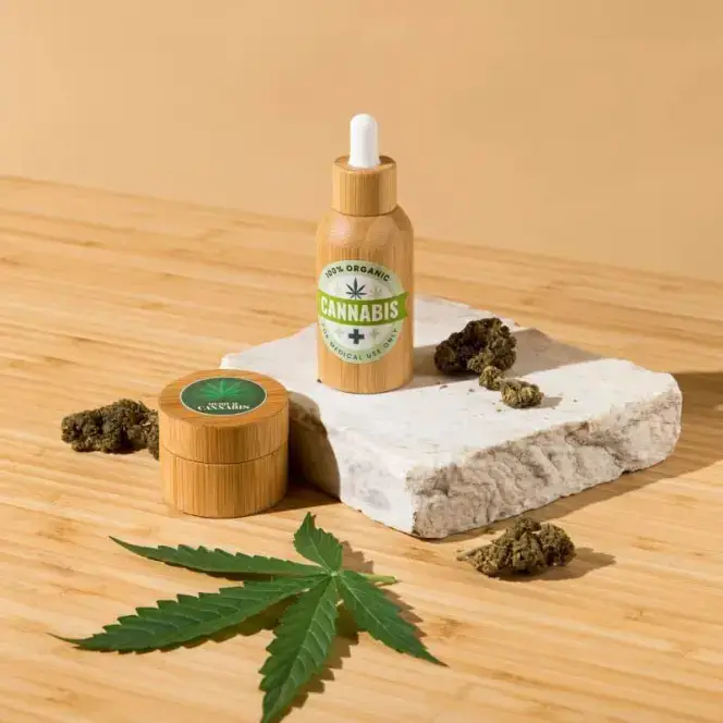 CBD bottle and jar staged on a stone riser on a warm wooden table.